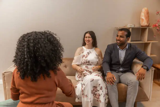 Counselor guiding couple through conflict resolution exercise during focused relationship session , Counselor guiding couple through structured discussion on conflict and communication habits
