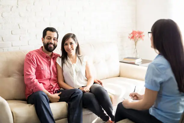 Counselor guiding couple through structured communication exercise during relationship therapy session