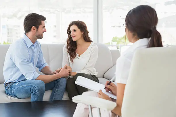Couple meeting with counselor before wedding to discuss communication and future expectations, Couple discussing communication concerns with counselor during a calm relationship session